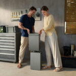 Thumbnail of  Een man en vrouw plaatsen een EcoFlow STREAM AC 5000 thuisbatterij op een tweede batterijmodule in een garage.