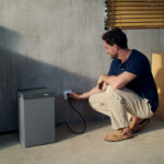 Thumbnail of  Een man sluit de EcoFlow STREAM AC 5000 thuisbatterij aan op een stopcontact in een modern interieur.