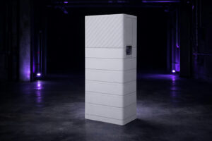 Witte FoxESS All-in-One H10 hybride omvormer en gestapelde batterijmodules in een donkere ruimte.