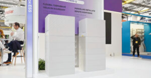 Twee witte modulaire FoxESS Power Q All-in-one thuisbatterijen opgesteld in een beursstand.