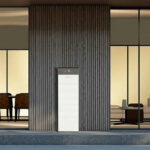 Thumbnail of  Witte Pylontech thuisbatterij met H3X-5K omvormer geplaatst voor een houten wand bij een moderne woning.