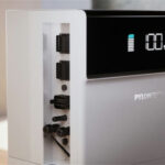 Thumbnail of  Detail van de Pylontech H3X omvormer met display die een batterijniveau van 100% en diverse kabelaansluitingen toont.